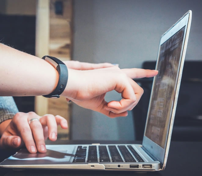 Employees pointing at the screen of the laptop. Photo by John Schnobrich via Unsplash